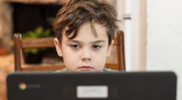 young boy looking at laptop